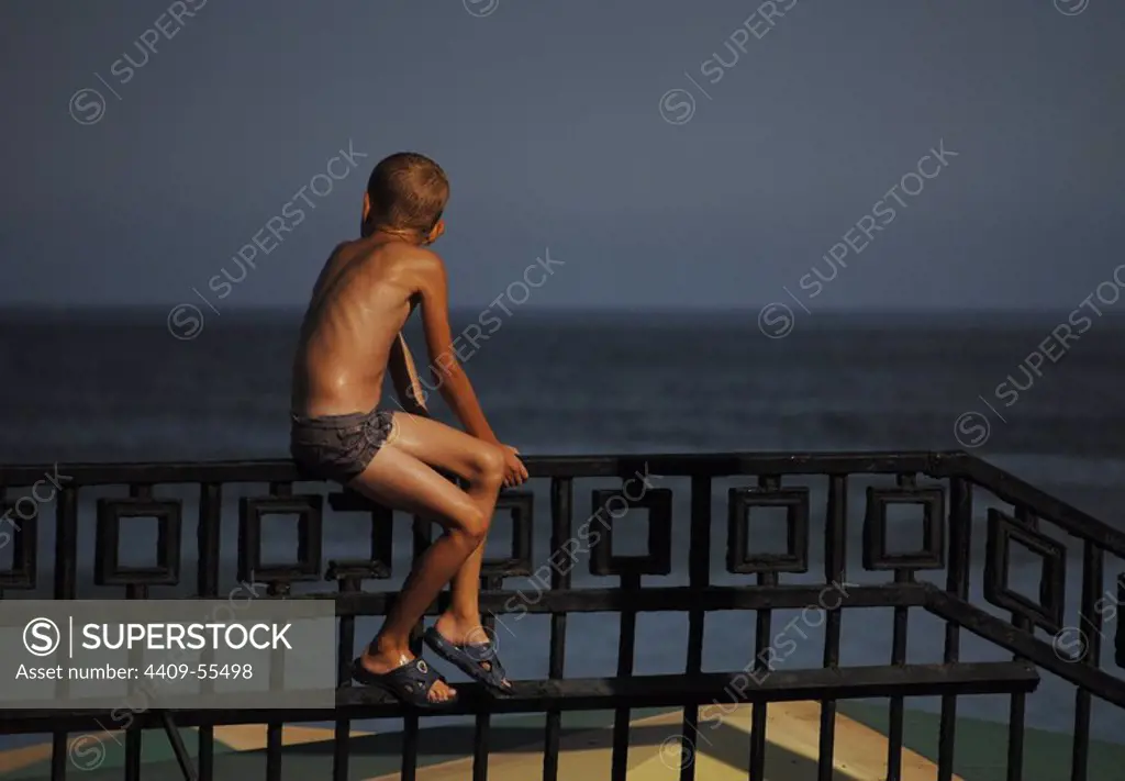 Autonomous Republic of Crimea. Feodosiya. Child sitting in a railing.