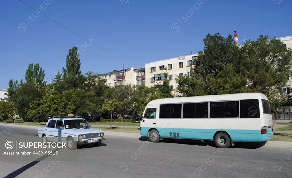 Ukraine. Autonomous Republic of Crimea. Feodosiya. Taxi and typical Marshrutka circulating along a street.