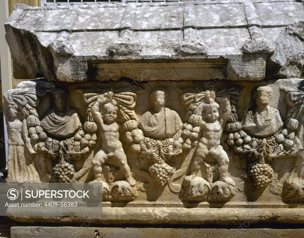 Detail of one of the faces of a Roman sarcophagus, depicting the deceaseds. Two cupids hold a garland of fruits and flowers along the entire relief. Ancient city of Aphrodisias. Turkey, Anatolia.