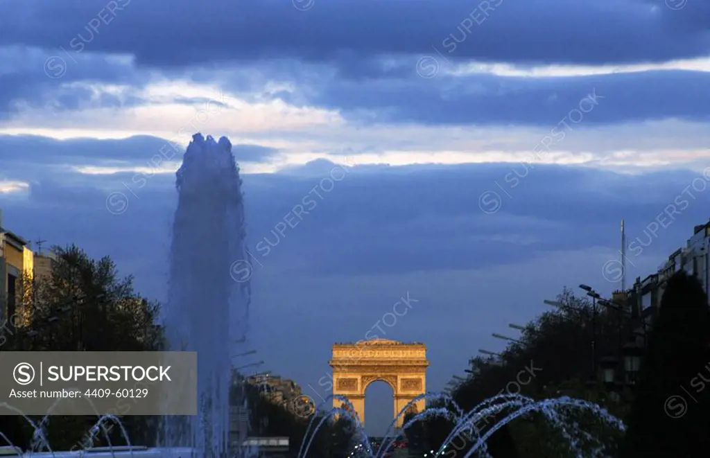 France. Paris. Night view of the Champs Elysees with the Triumphal Arch in the background.