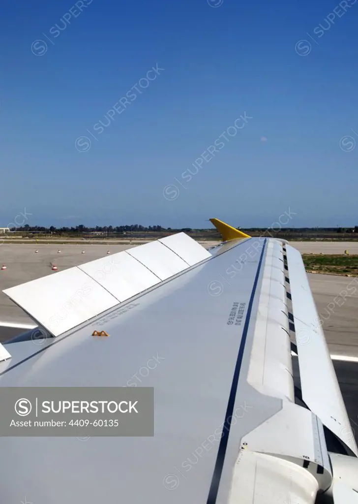 Wing of a plane with the flaps and slats deployed to reduce the speed.