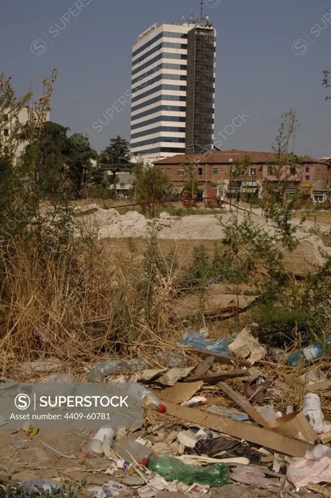 Contraste POBREZA-MODERNIDAD entre el nuevo edificio del Hotel Internacional y el descampado lleno de desperdicios de los alrededores. Tirana. República de Albania.