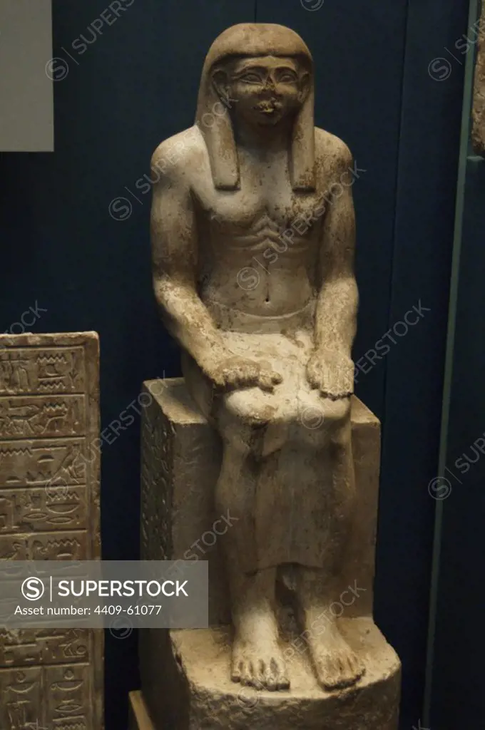 Intef's seated statue. Limestone. Wearing with a wig, long skirt and with abdominal folds with which scuptor shows Intef's high social status, associated to abundant food and sedentary lifestyle. 1930 BC. 12th Dynasty. Chapel of Intef, Abydos, Egypt. British Museum. London. United Kingdom.