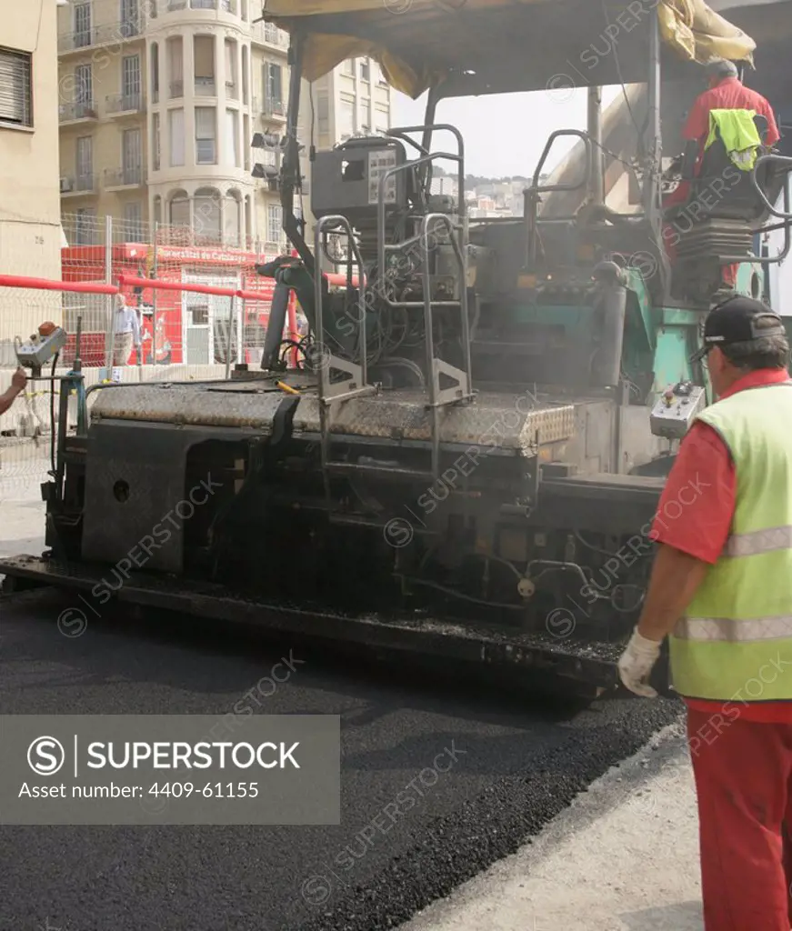Paving work. Asphalt paving machine. New asphalt surface on the carriageway. Barcelona. Spain.