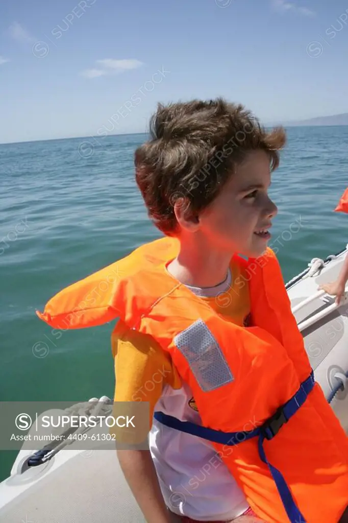 Spain. Catalonia. Young boy with life jacket on a boat.