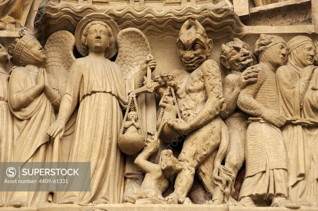 Gothic Art. France. Paris. Notre Dame. Sculptures decorating the portal of the Last Judgment. It was built in the 1220s-1230s. Facade. The archangel Michael is weighing their souls with a furry Devil's interference. Paris.
