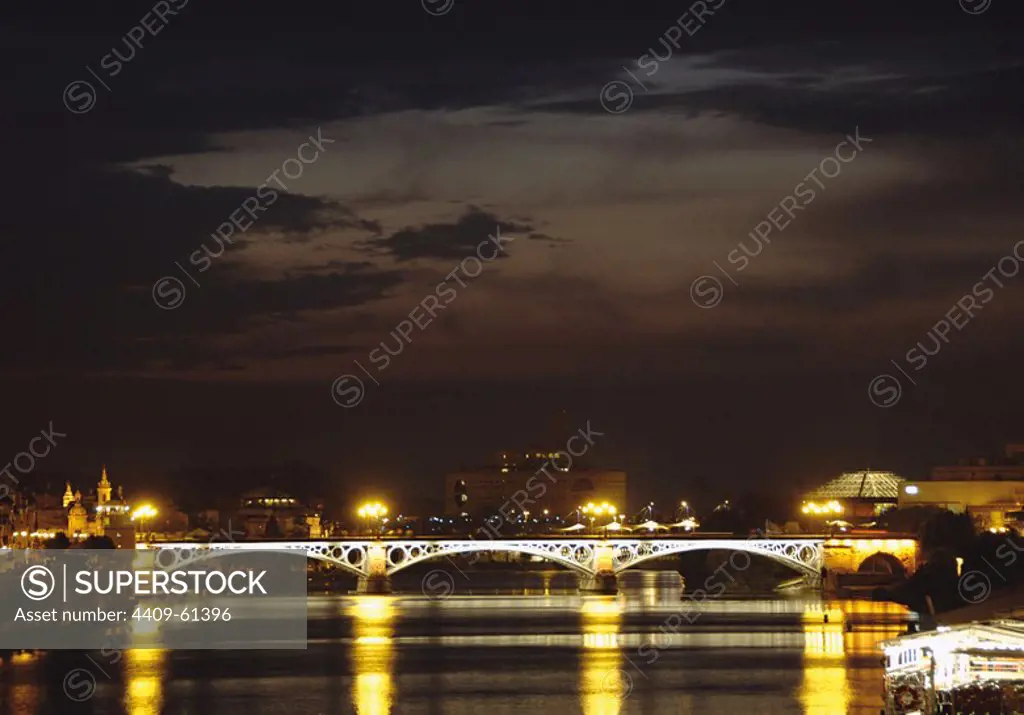 Spain. Andalusia. Sevilla. Night view of Isabel II Bridge, also known as Triana Bridge on the River Guadalquivir. Built between 1847 and 1852 by Bernadette and Steinacher.