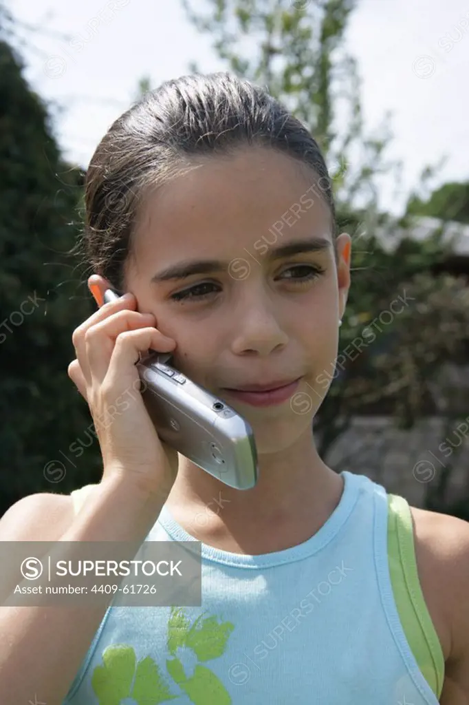 NIÑA de 8 años hablando por teléfono móvil.