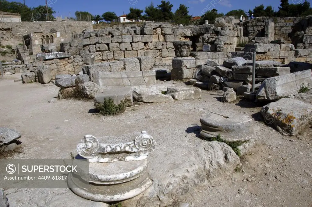 Greece. Ancient Corinth (polis). Ruins of the archaeological site. In the foreground remains of Ionic capital with volutes. Peloponnese region.