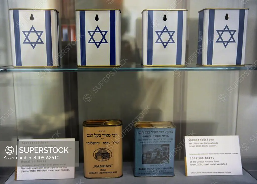 Donation boxes. Jerusalem, about 1940-1941, sheet metal. It shows a pictures of the grave of Rabbi Meir Baal Hanes near Tiberias. On the top, boxes of the Jewish National Fund Israel, 2001, sheet metal, varnished. Jewish Museum Berlin. Germany.