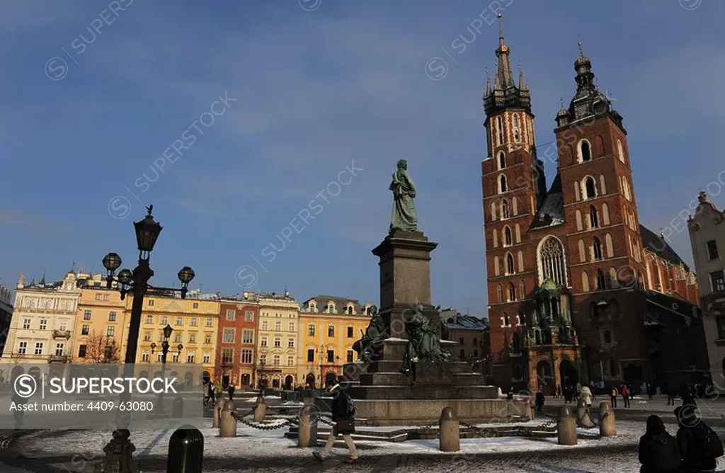 Poland. Krakow. Main Market Square. Adam Mickiewicz Monument in front of the St. Mary's Basilica, built in 14th century in Brick Gothic architecture style.