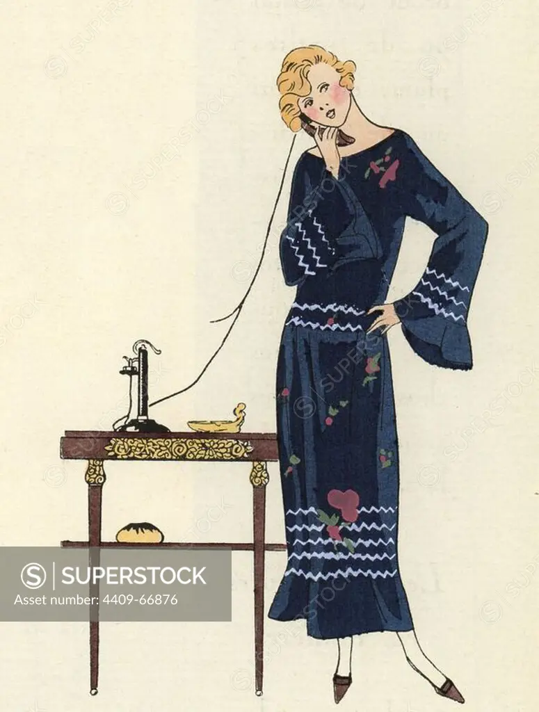 Young woman on the telephone wearing a marine blue serge dress with white lines and flowers. Handcolored pochoir (stencil) lithograph from the French luxury fashion magazine "Art, Gout, Beaute" 1923.