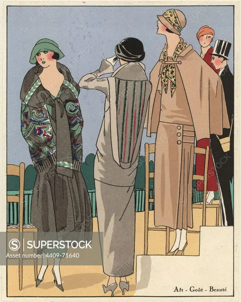 Women at the races in fashionable day wear: cape in black crepe satin embroidered with cashmere, dress in grey wool, and beige three-piece suit with printed scarf. Handcolored pochoir (stencil) lithograph from the French luxury fashion magazine "Art, Gout, Beaute" 1923.