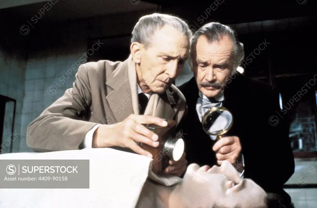 JOHN MILLS and PETER CUSHING in SHERLOCK HOLMES AND THE MASKS OF DEATH (1984) -Original title: THE MASKS OF DEATH-, directed by ROY WARD BAKER.
