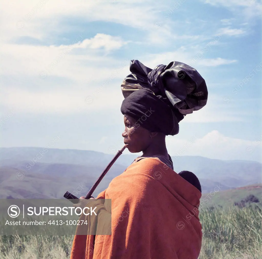 Xhosa woman with a traditional style turban smoking pipe