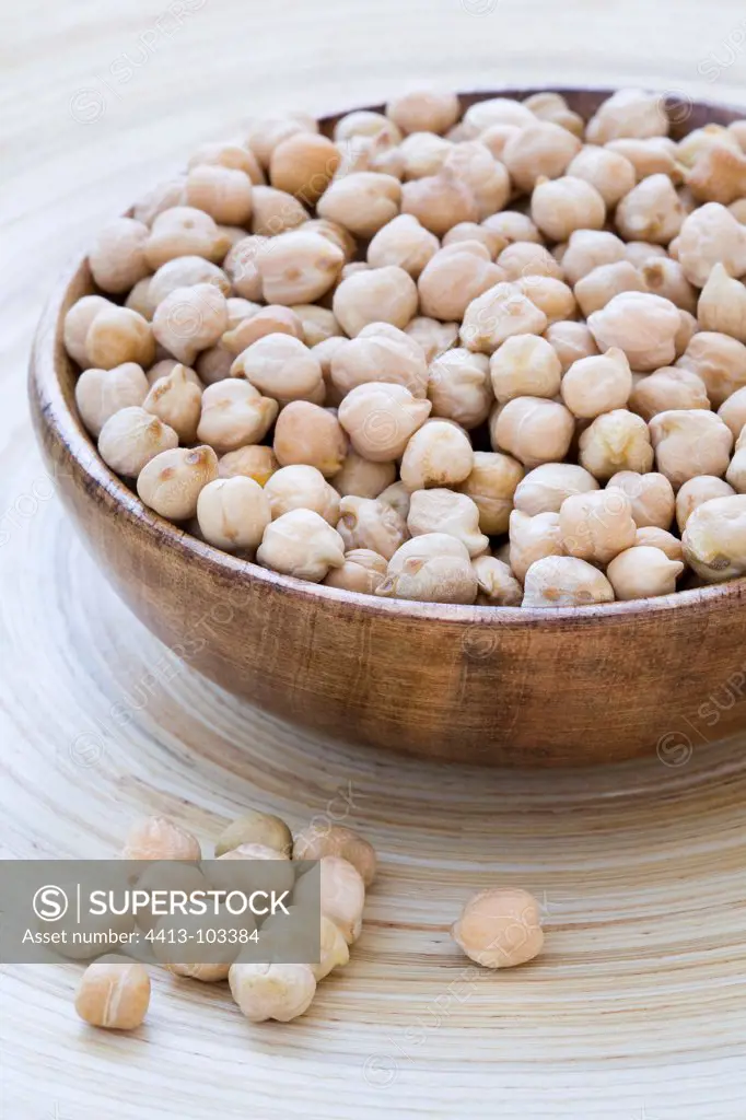 Chickpeas in a wooden bowl on a wooden tray