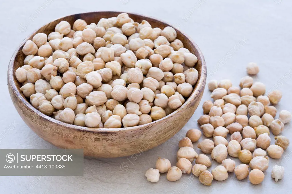 Chickpeas in a wooden bowl on a wooden tray
