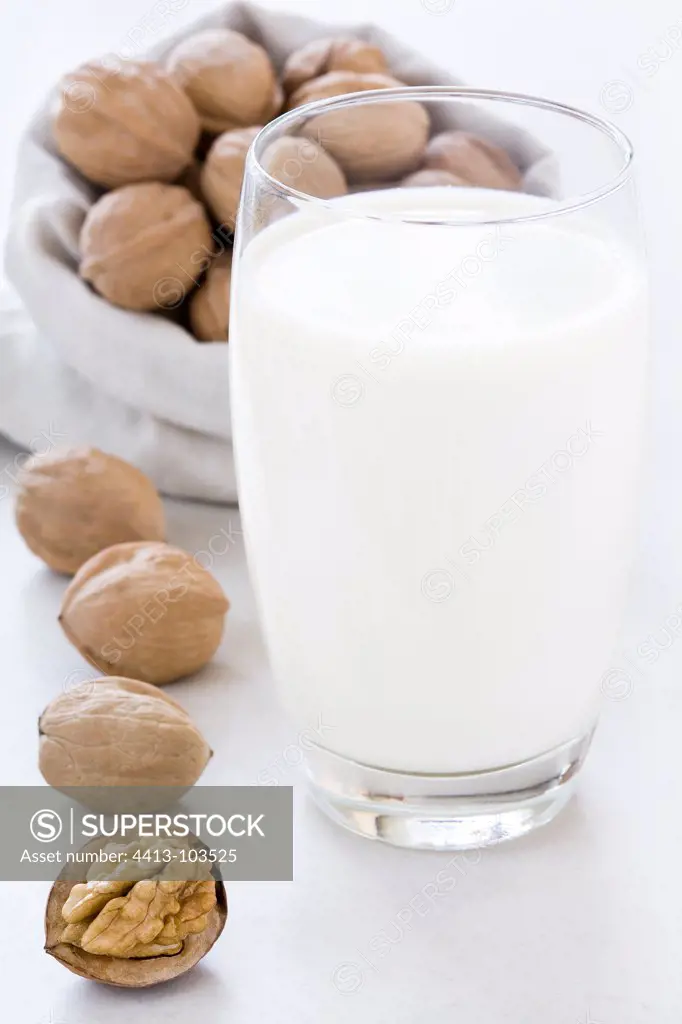 Glass of milk nuts and walnuts in a bag