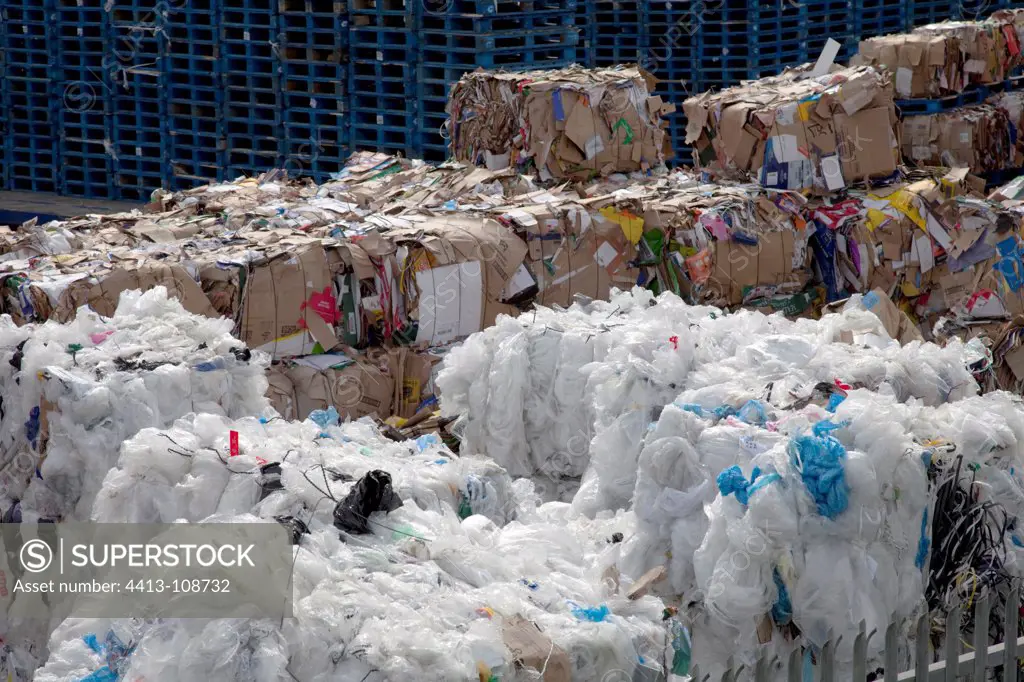 Bales of plastic and cardboard waste outside warehouse UK