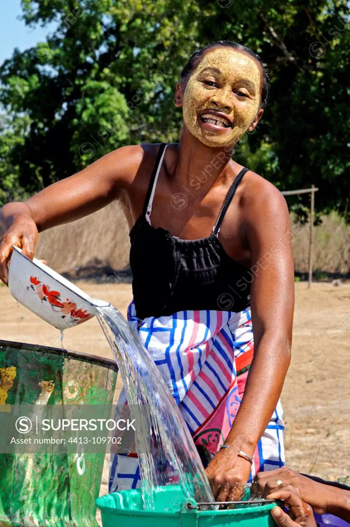 Woman wearing a facial mask at the wellhead Madagascar