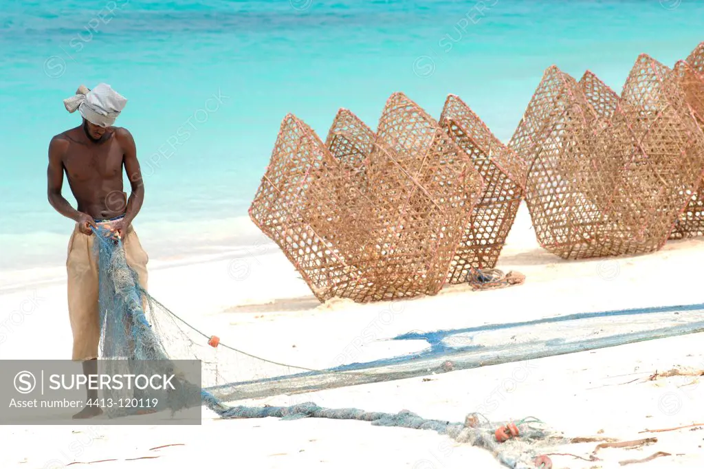 Fisherman with net and trap fishing Unguja island Zanzibar
