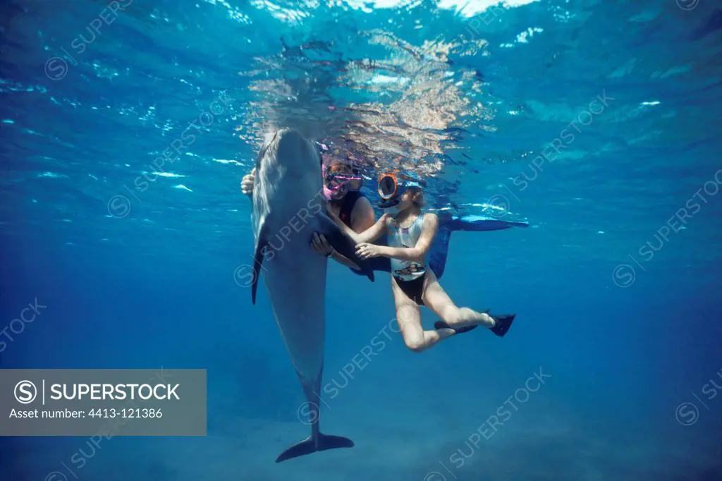 Dolphin trainer and autistic child interacting with Dolphin