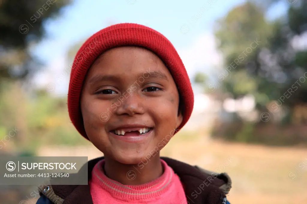 Portrait of a toothless boy wearing a red cap Nepal