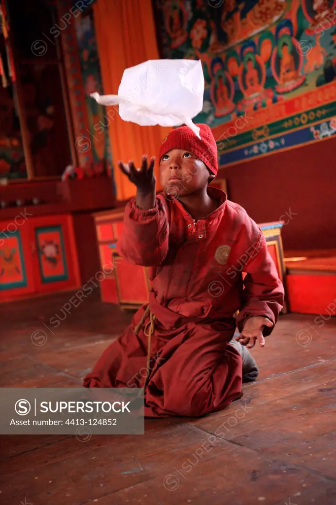 Young Buddhist monk playing with a packet Muktinath Nepal