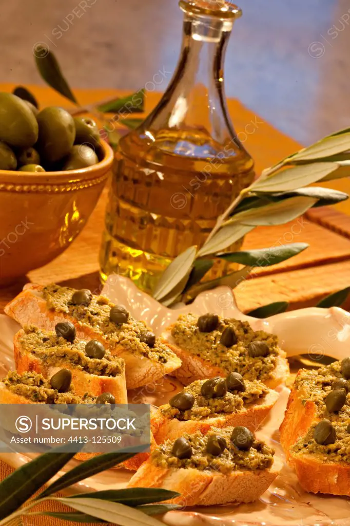 Toasts of green tapenade and capers with olive oil