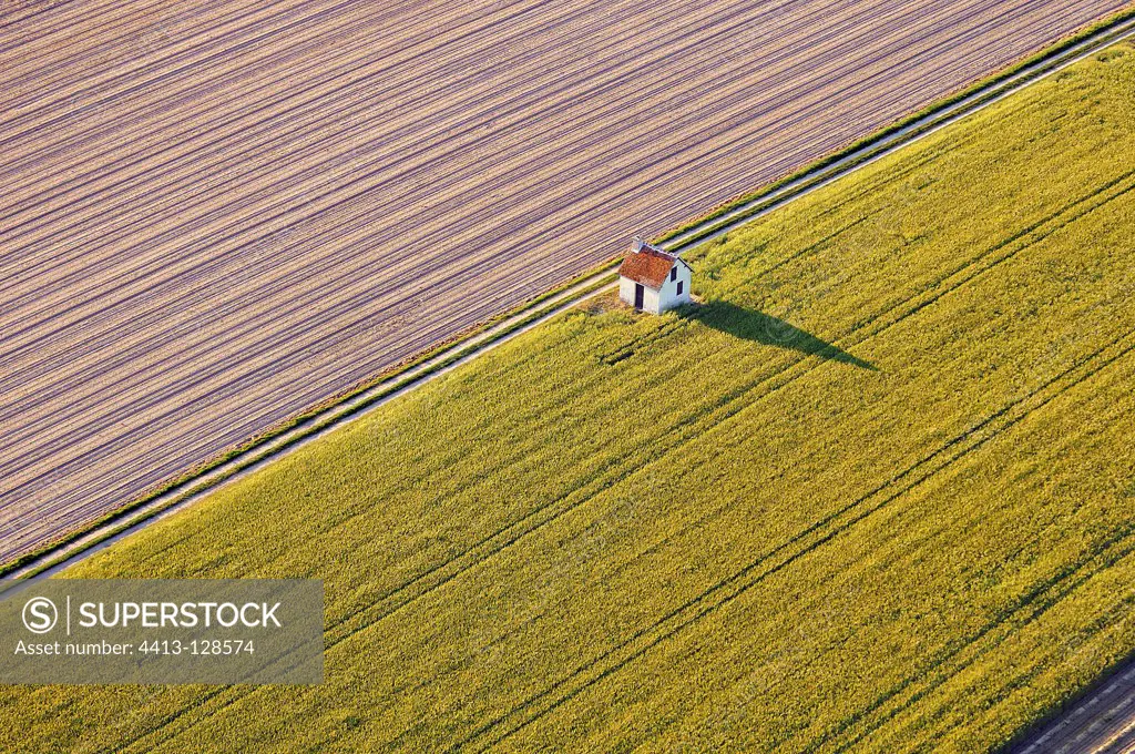 Aerial view of a garden shed in a field of rapeseed France