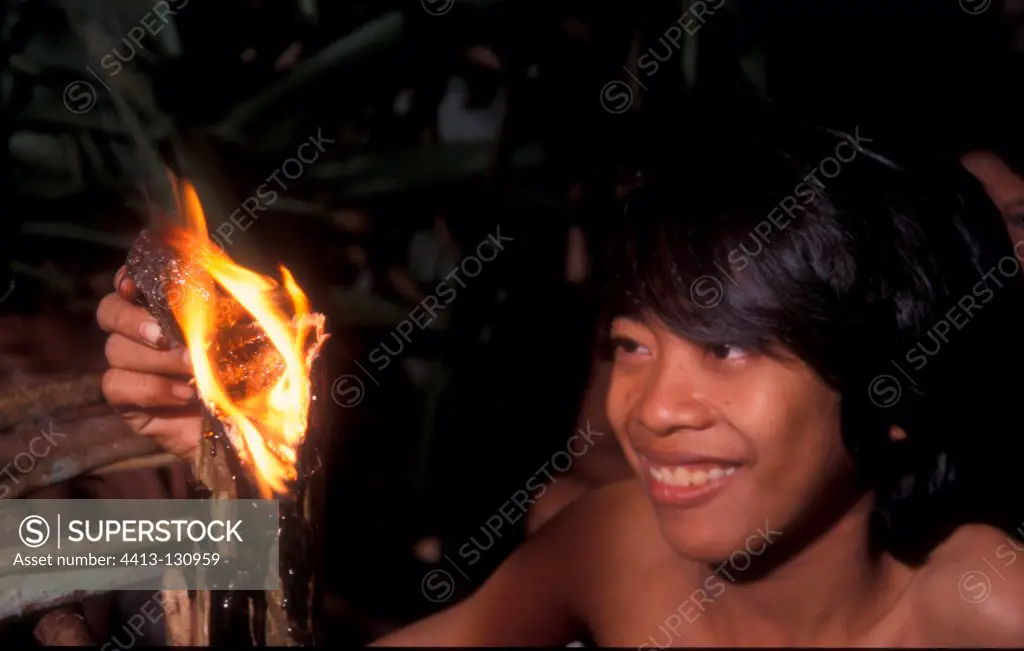 Boy burning resin from Damar tree Bukit Duabelas NP Sumatra