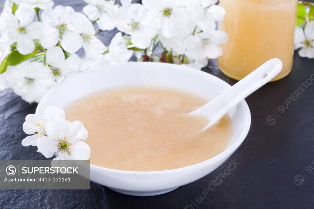 Cherry honey in a dish with white flowers