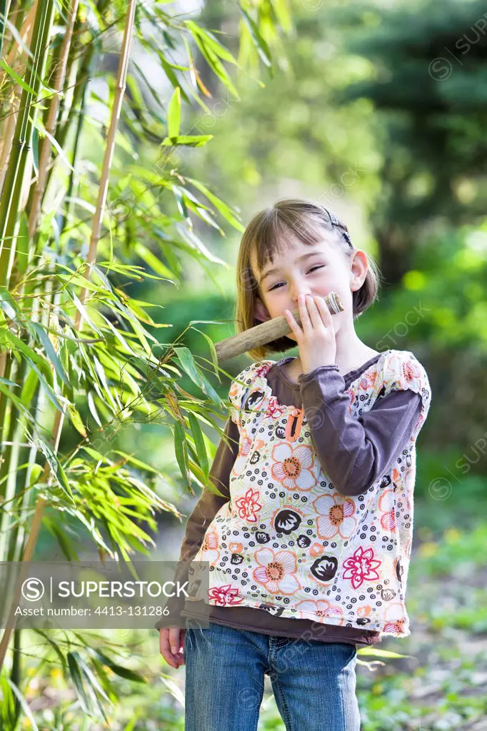 Girl playing a kazoo reed and paper