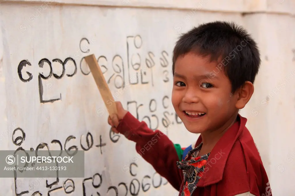 Child deciphering inscriptions on a wall Burma