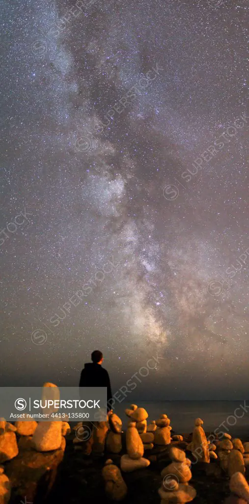 Person observing the Milky Way over rocks