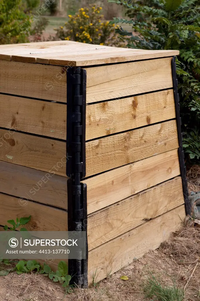Wooden compost container in an organic garden
