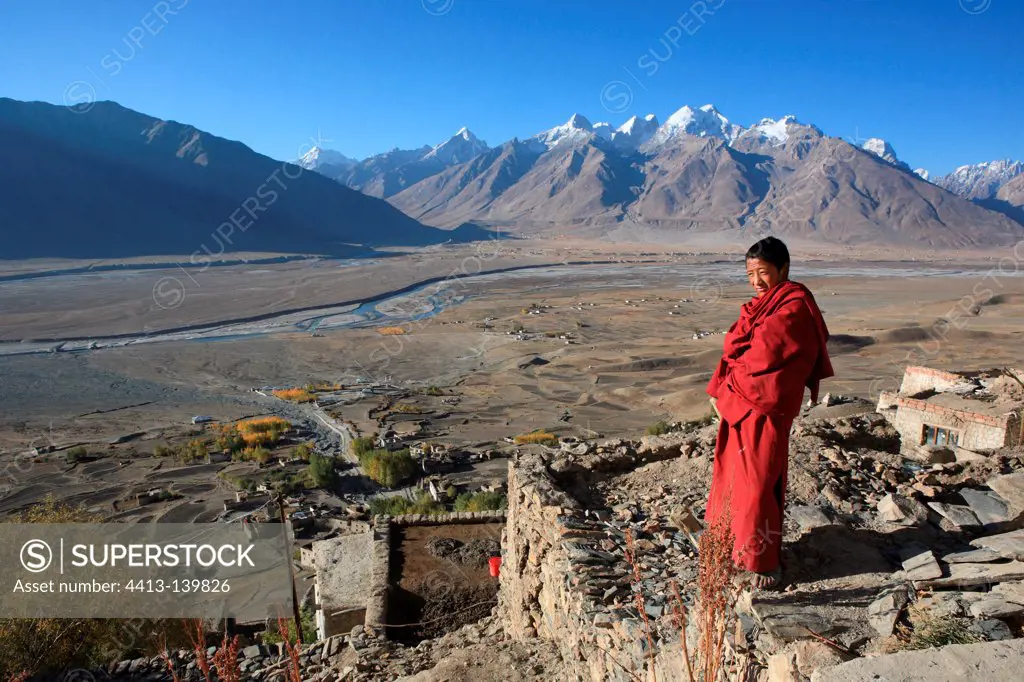 Monk on a roof and mountain Zanskar Ladakh Himalayas India
