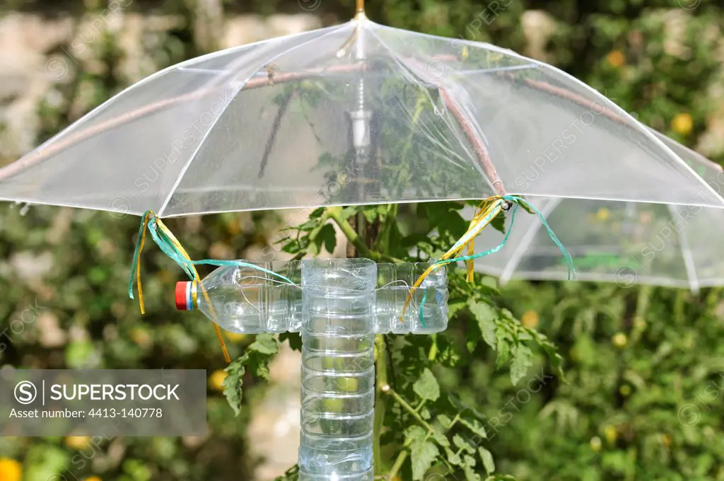 Sprinkler system with bottles and umbrellas in a park