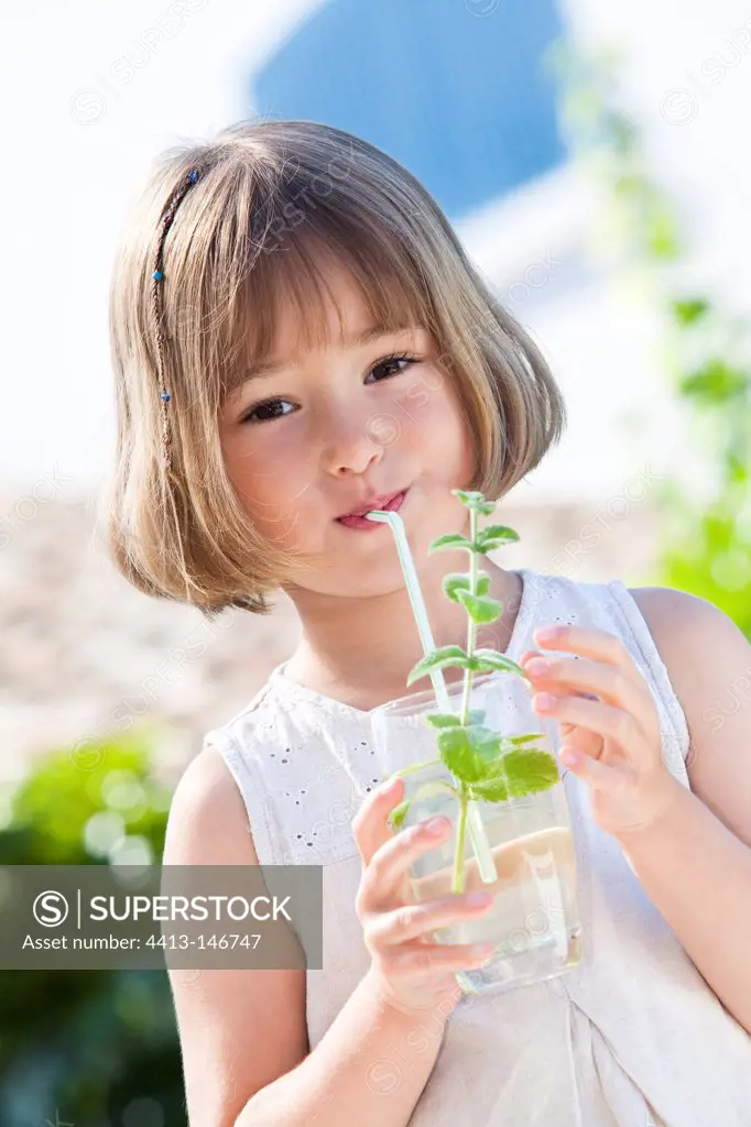 Little girl drinking a mint drink