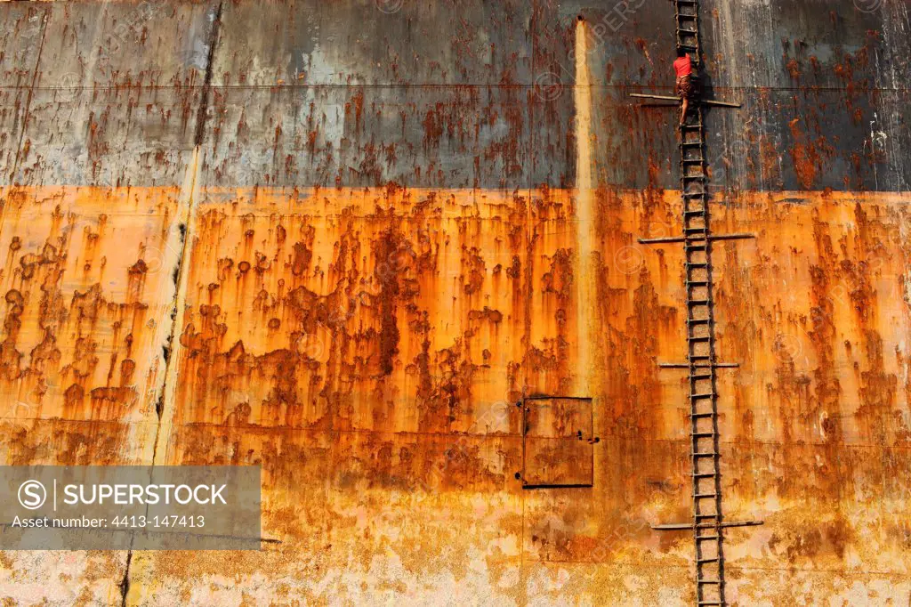 Worker climbing a ladder by boat Bangladesh