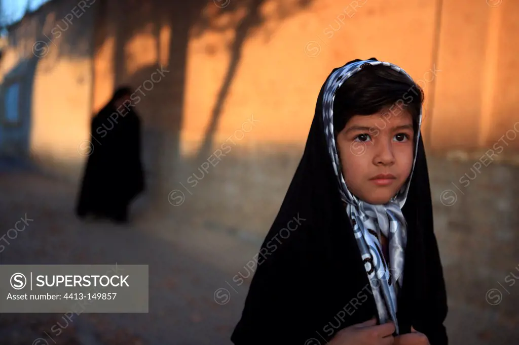 Veiled girl walking down the street in Yazd Iran
