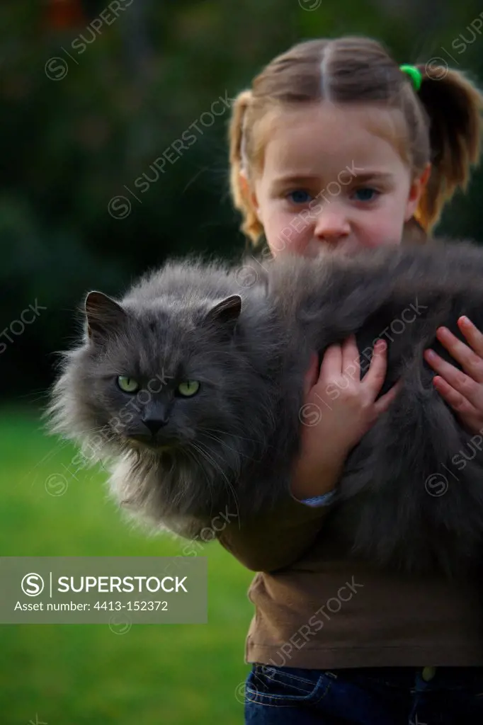Child holding a cat in her arms