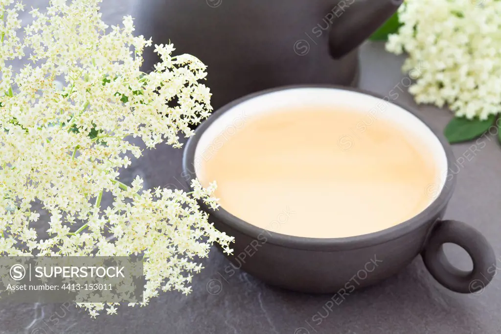 Elderflower and elderberry herbal tea in a black cup