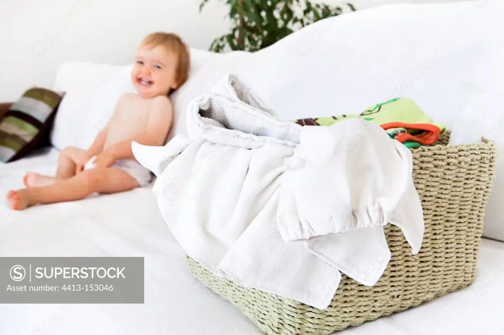 Boy sitting and Diapers on a basket on a couchFrance