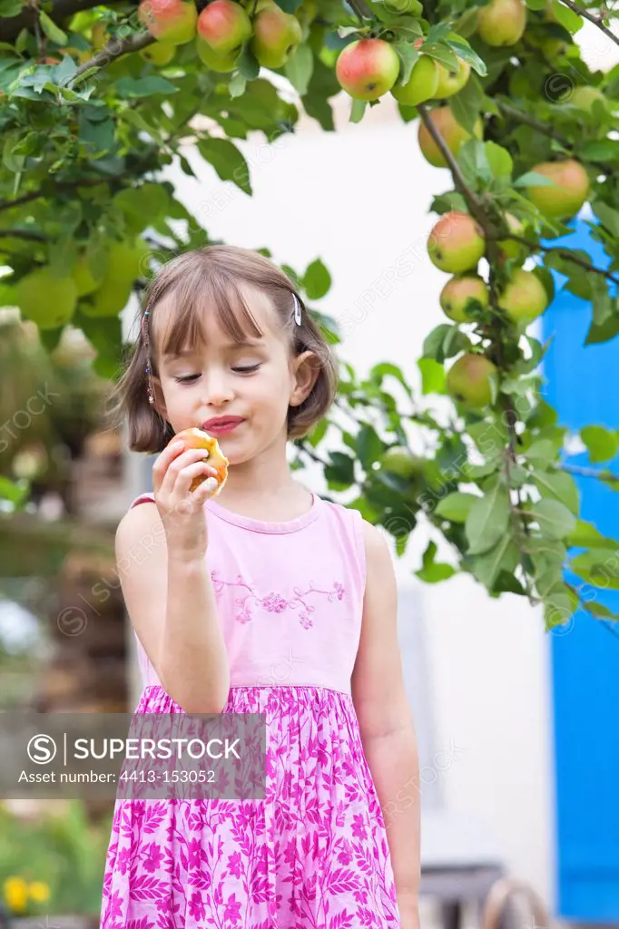 Girl eating an apple in a garden France