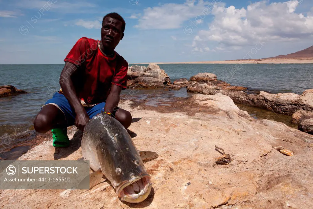 Turkana fisherman on the shores of Lake Turkana with a perch