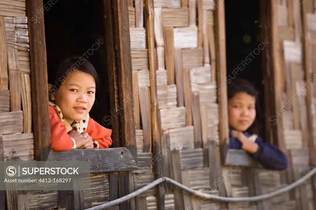 Child at the window of a bamboo house Burma