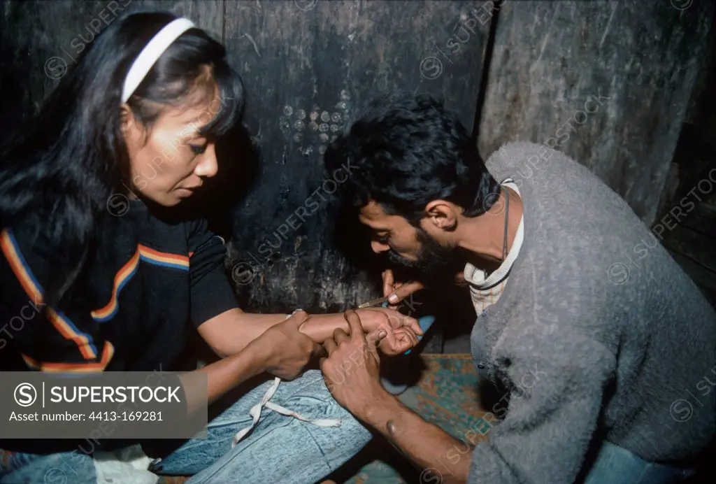 Drug addicts sharing needles to inject heroin Bombay India