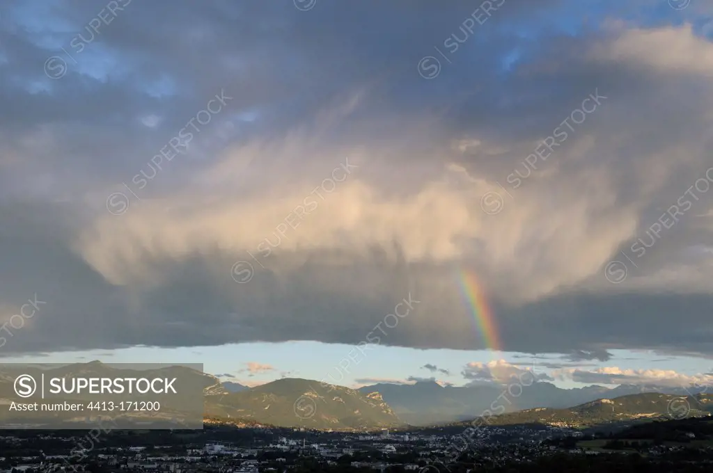 Cumulus clouds and rain under rainbow sky above Chambéry