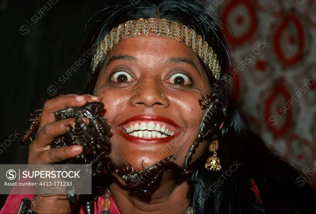 Girl snake charmer with scorpions on her face India